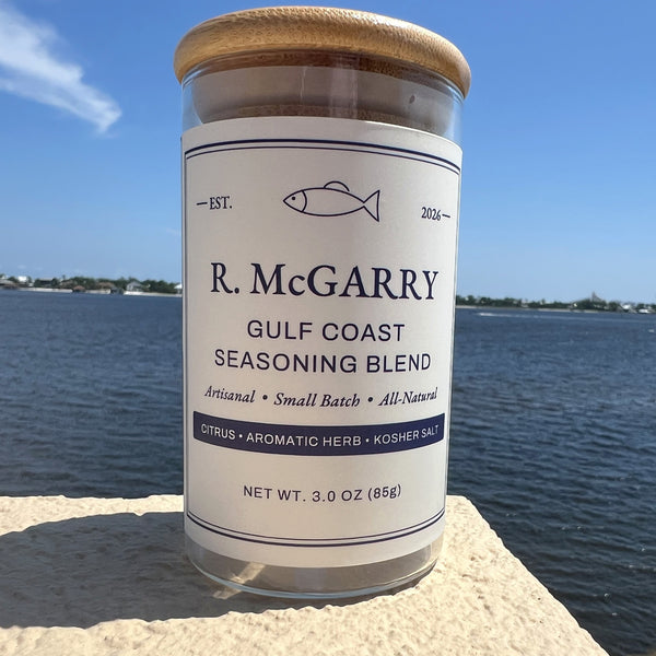R. McGarry Gulf Coast Seasoning Blend jar with bamboo lid on a stone ledge overlooking the water