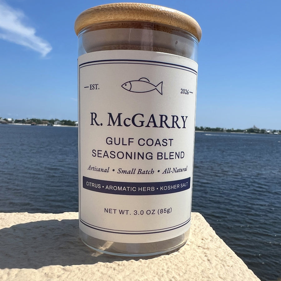 R. McGarry Gulf Coast Seasoning Blend jar with bamboo lid on a stone ledge overlooking the water
