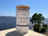 Gulf Coast Seasoning Blend jar overlooking the bay with coastal pines