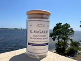 Gulf Coast Seasoning Blend jar on a seawall with shoreline view